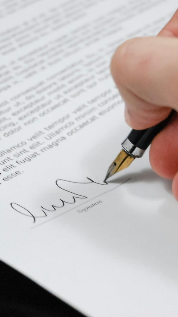 document-agreement-documents-sign-48148-48148 Close-up of a hand signing a legal document with a fountain pen, symbolizing signature and agreement.