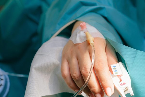 pexels-photo-3845126-3845126 Close-up of a patient's hand with intravenous therapy and pulse oximeter, symbolizing healthcare and treatment.