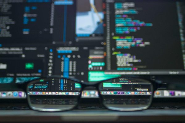 pexels-photo-577585-577585 Eyeglasses reflecting computer code on a monitor, ideal for technology and programming themes.