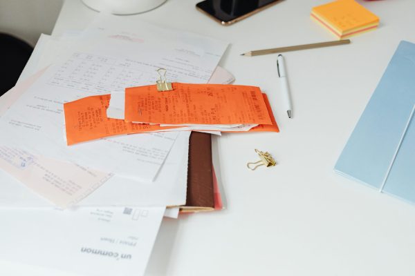 pexels-photo-7680681-7680681 Close-up of a tidy desk with receipts, documents, and office stationery for business organization.